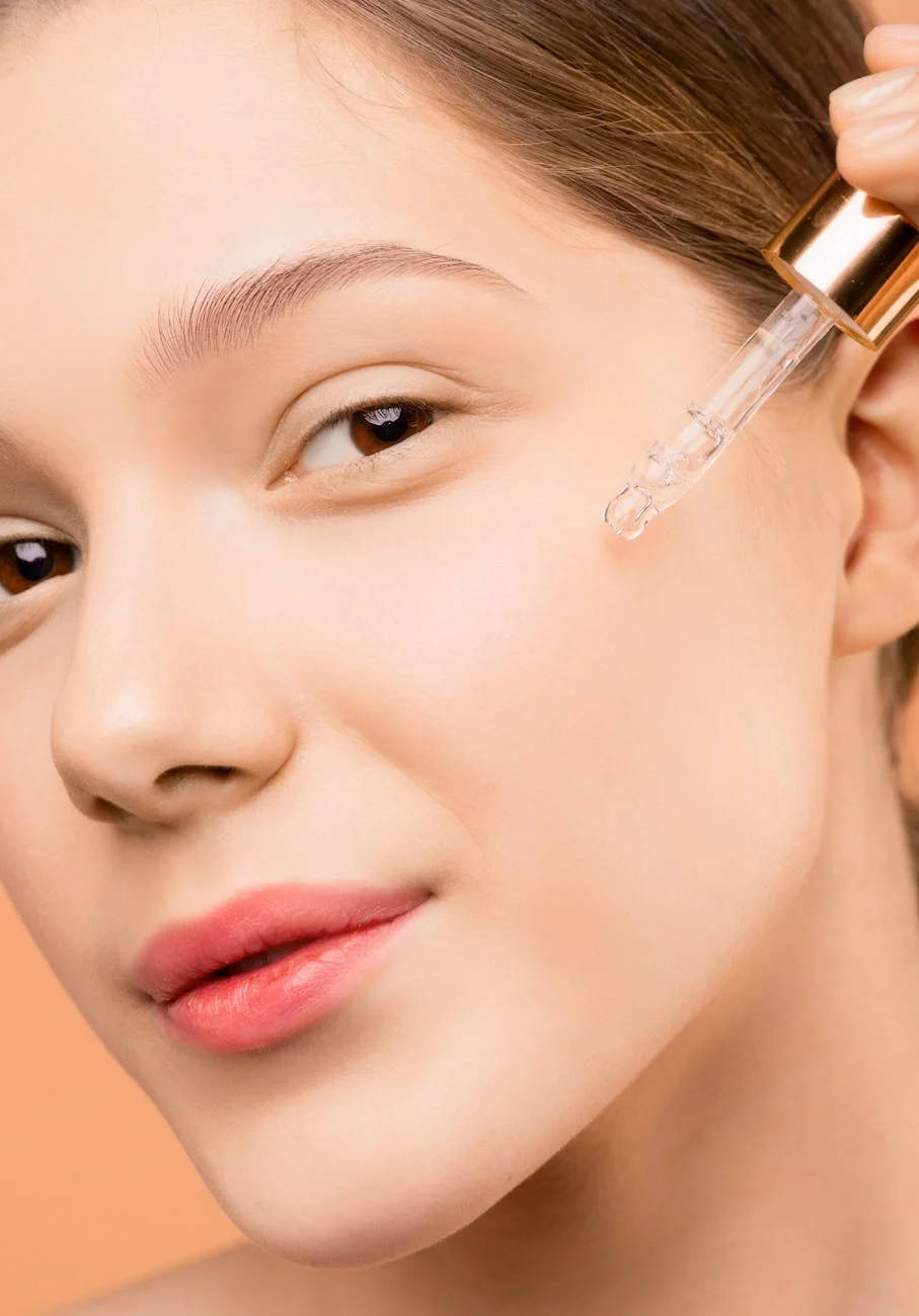 Visage souriant appliquant un serum