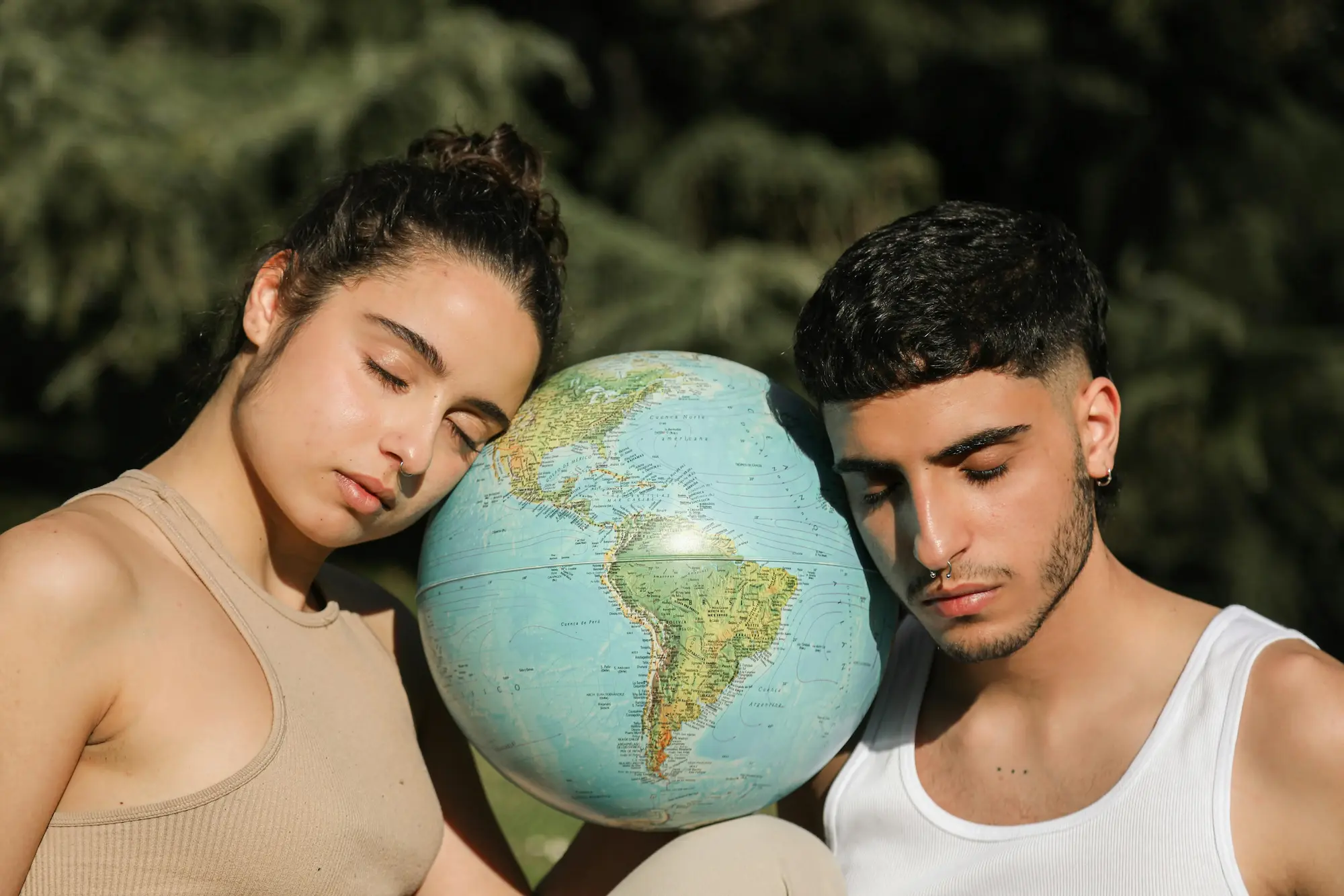 Un homme et une femme qui reposent leurs tête sur un globe terrestre