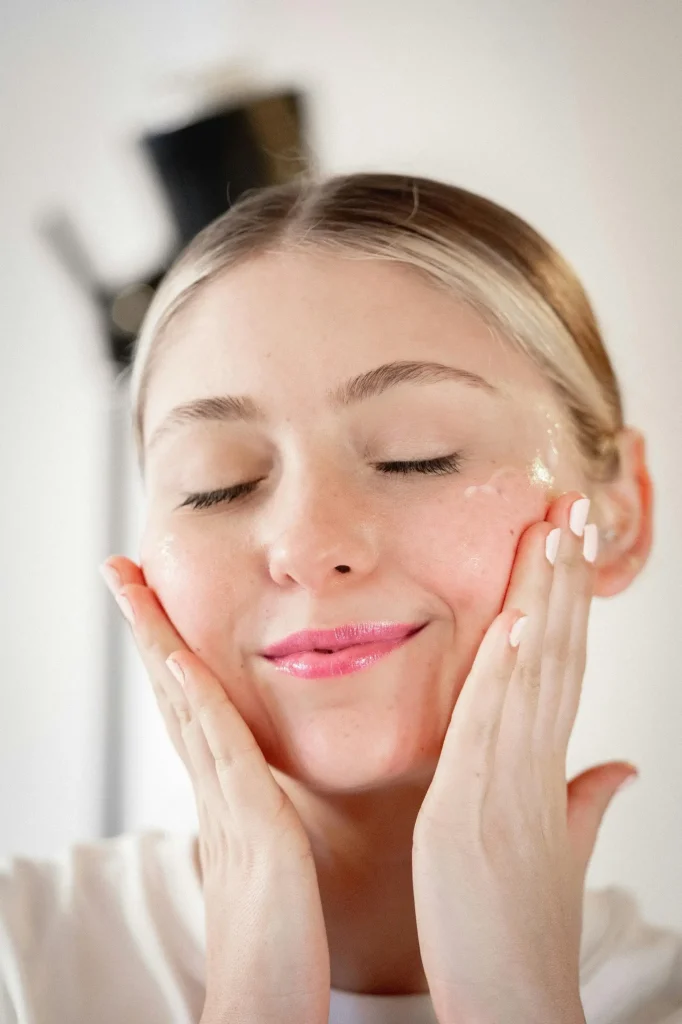 Jeune femme souriante qui applique le gel nettoyant