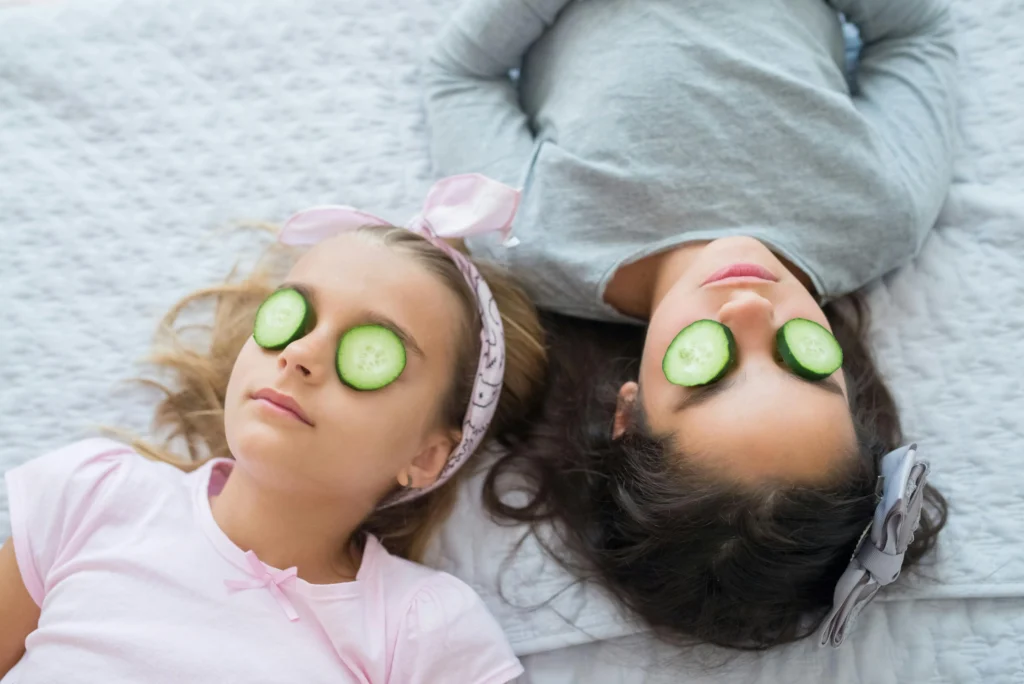 Deux jeunes filles avec des rondelles de concombre sur les yeux