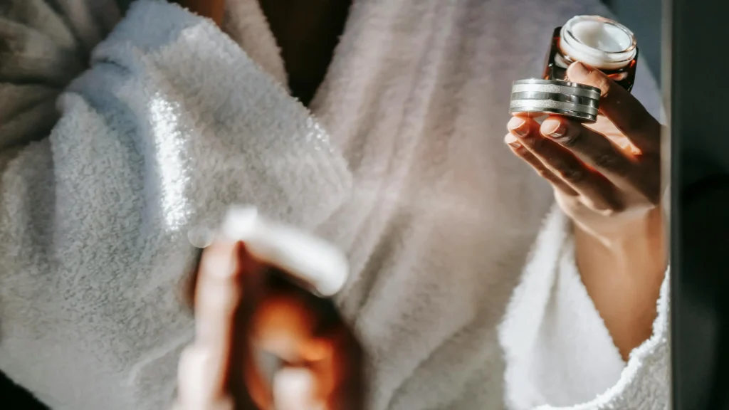 Flacon de gel hydratant tenu par une femme en peignoir