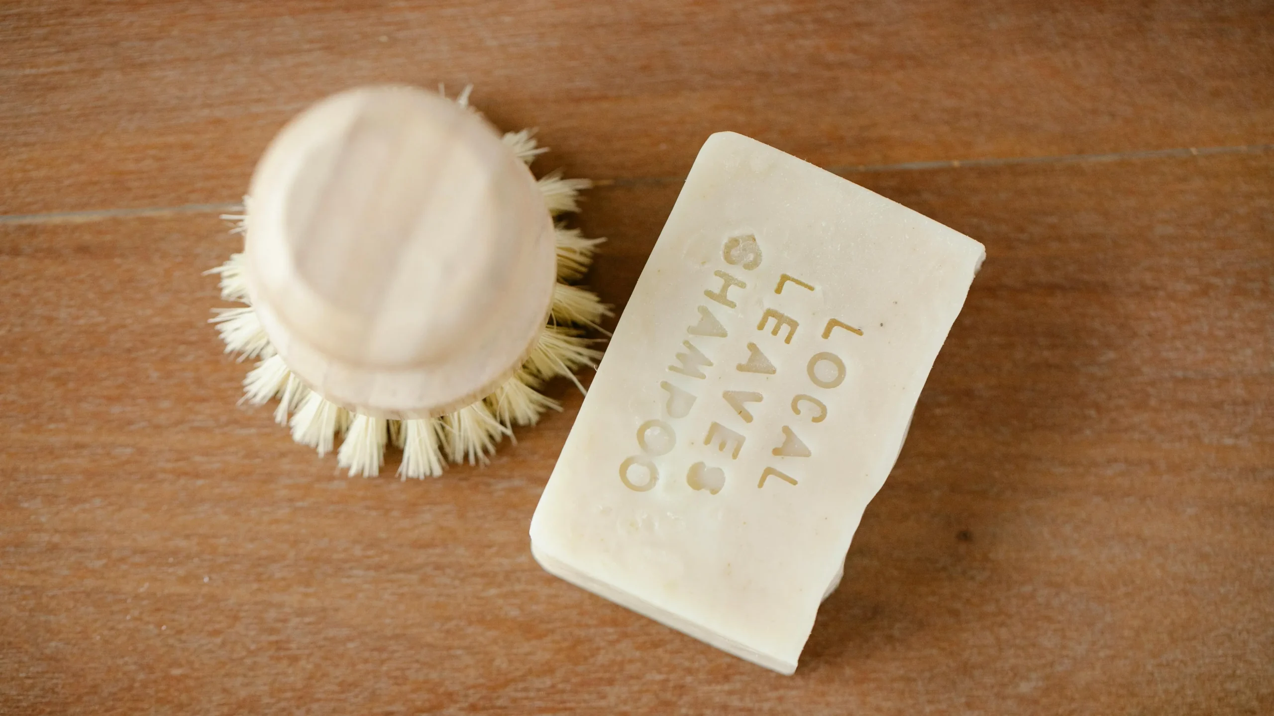 shampooing solide et brosse sur table en bois