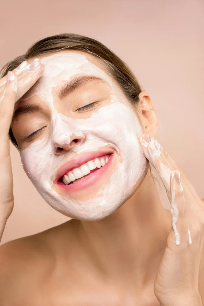 Femme souriante avec un masque à l'argile sur le visage